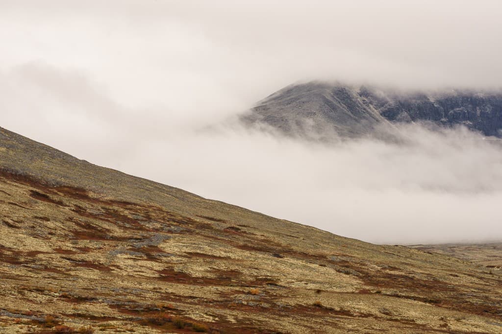 Molnband som sveper in över höstfjäll — Rondane nationalpark