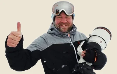 Naturfotografen Niklas Virsen i fält med teleobjektiv och tumme upp